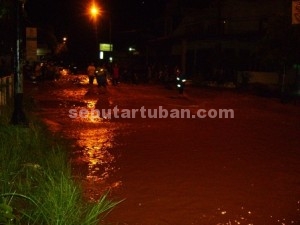 JADI SUNGAI : Kawasan jalan Letda Soetjipto Tuban juga terendam banjir, hingga melumpuhkan aktivitas warga dan pengguna jalan, Sabtu (27/12/2014)