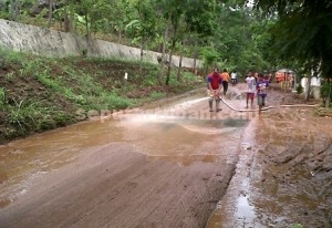 GERAK CEPAT : Petugas BPBD sedang membersihkan jalan yang dipenuhi lumpur