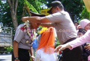 SELAMAT DATANG : Wakapolres Tuban, Kopol Ali Mahfudz saat mengalungkan bunga kepada Kapolres Tuban, AKBP Guruh Arif Darmawan saat memasuki pintu gerbang Mapolres Tuban