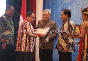 PRESTASI : Ketua Umum PWI Pusat, Margiono didampingi Ketua PWI Jatim, Akhmad Munir menyerahkan award kepada Direktur Utama PT Semen Indonesia, Suparni