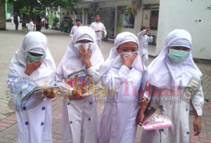 Siswa menutup hidung dari abu Kelud