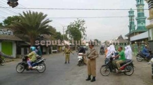  ISTIMEWA: Dua polisi tengah mengatur lalu lintas di perempatan depan Masjid Baiturrahman Jenu, Senin (10/11/2014) pagi.   