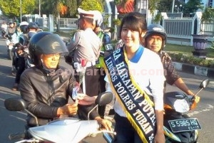 Semangat : Salah satu Duta Lalu Lintas Polres Tuban saat membagikan bunga kepada pengguna jalan