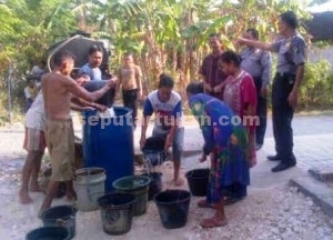 KEMANUSIAAN: Jajaran Polsek Semanding saat memberikan droping air bersih ke Desa Genaharjo. 