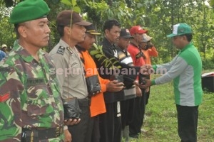 SIMBOLIS : Camat Montong, Agus Wijaya saat menyerahkan bibit pohon kepada perwakilan peserta apel